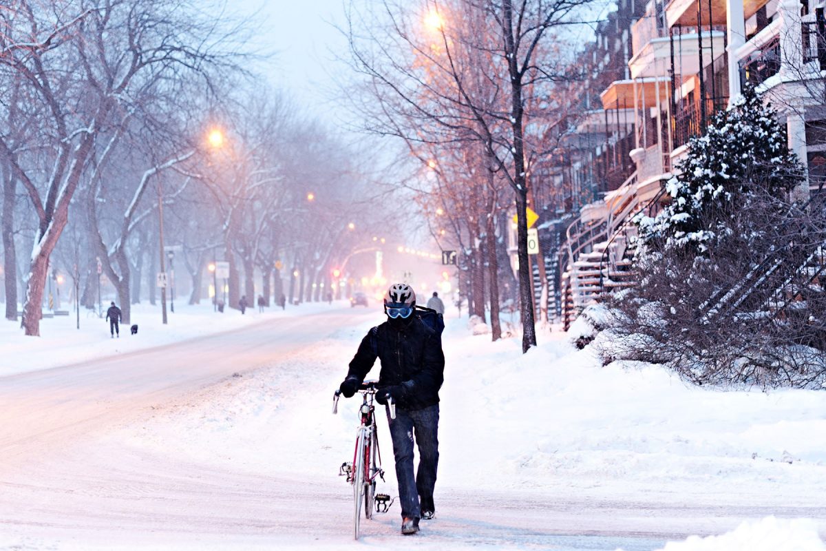 Editorial Travel Photography, Cyclist walking in snow storm on laurier avenue, plateau Mont Royal, Montreal, Quebec, Canada