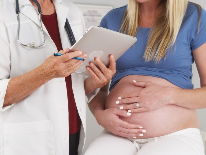 Pregnant woman and doctor in office