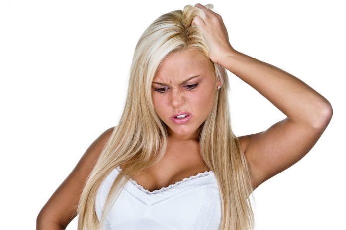 Confused Young Blonde Caucasian Woman Scratching her Head