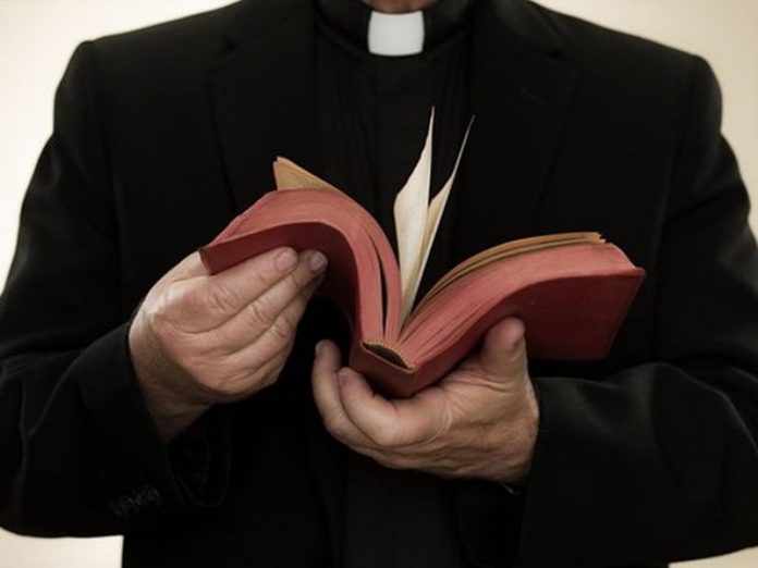 Priest holding a bible