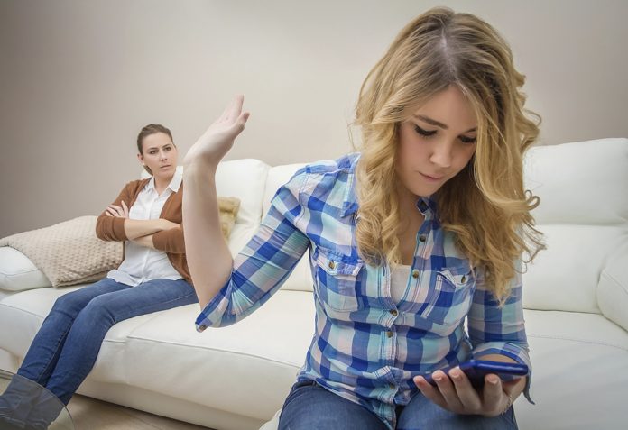 Daughter looking a phone and ignoring her mother