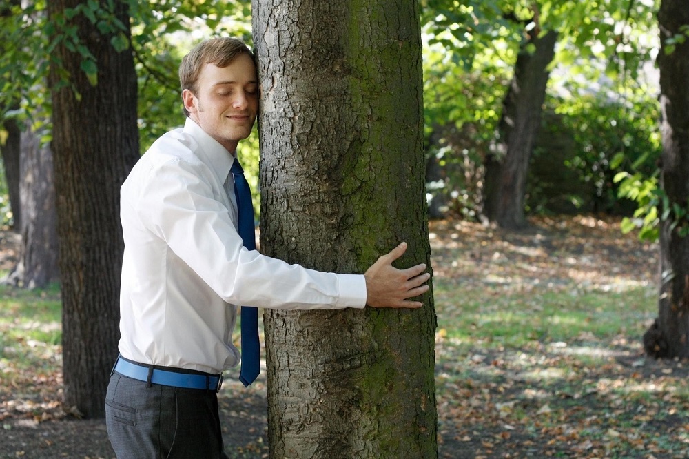 мужчина обнимает дерево